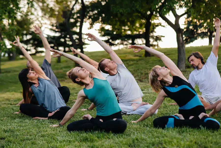 grupo-personas-haciendo-yoga-parque_180601-6959