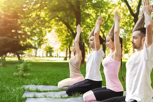 practicando-yoga-juntos-grupo-personas-meditando-al-aire-libre-haciendo-ejercicio-respiracion-parque-espacio-copia_116547-9684